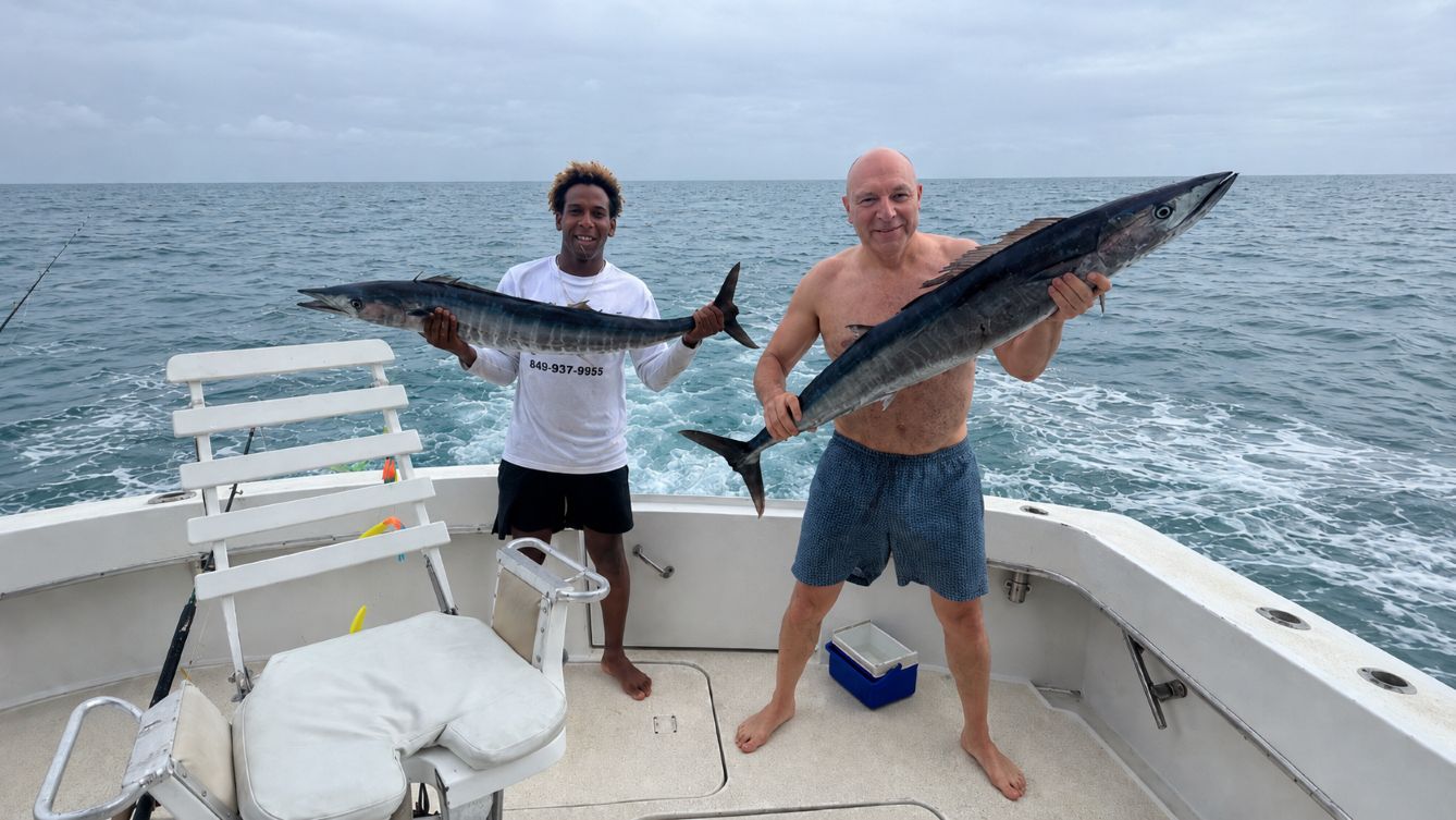 Two anglers holding large wahoo caught on a deep-sea fishing charter off the north coast of the Dominican Republic