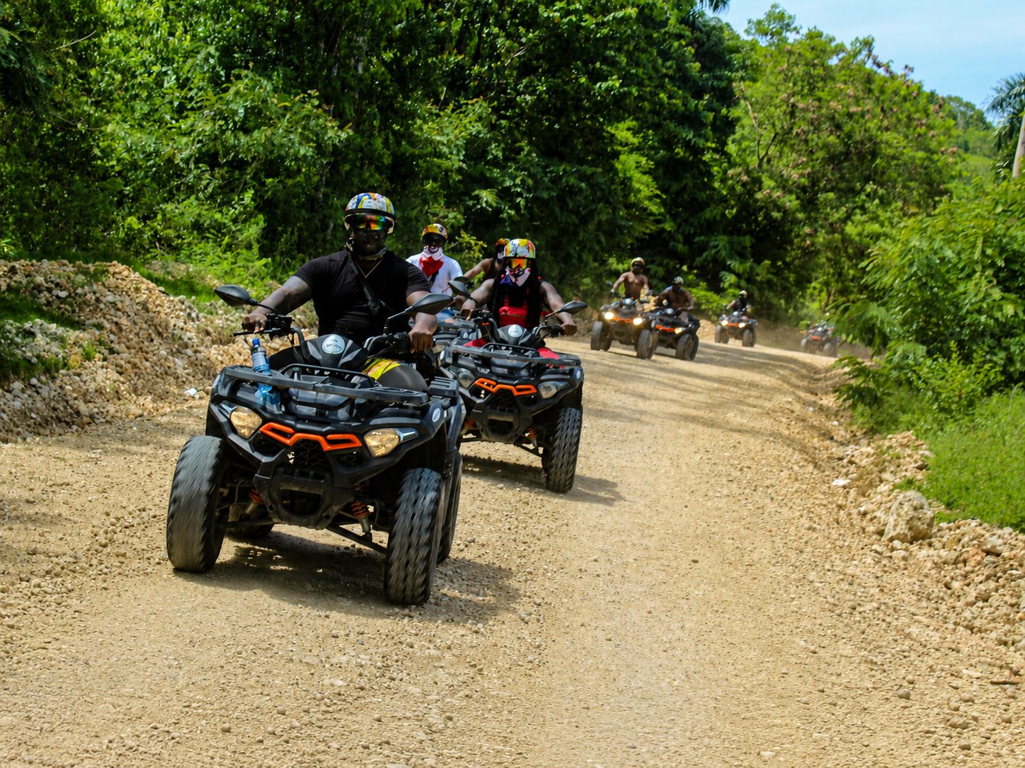 Group of guests riding ATVs along a countryside trail on a BlueCasas ATV tour near Sosúa, Dominican Republic