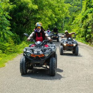 Guests riding quads on a jungle road surrounded by tropical greenery on a BlueCasas ATV tour