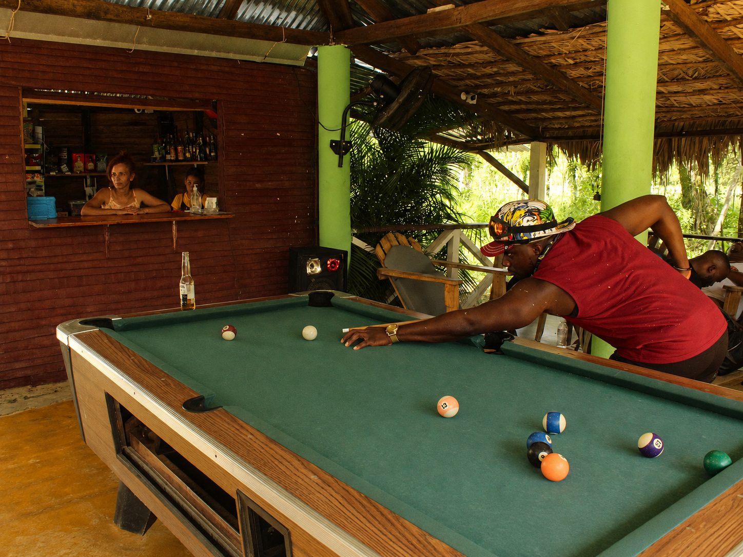 Tour guest playing billiards at an open-air local cafeteria stop during a BlueCasas ATV tour